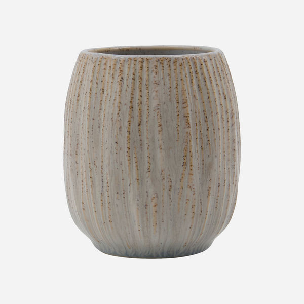 Gray ceramic tumbler with textured design on a light gray background